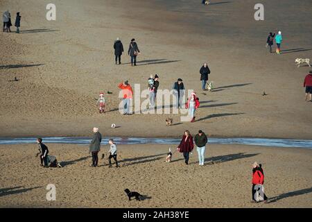 People walk on the beach at Tynemouth Long Sands ahead of the Christmas holiday. Stock Photo