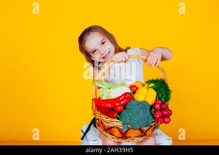 beautiful girl holding a basket of ripe vegetables healthy food Stock Photo