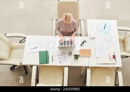 Elegant mature businesswoman working alone in modern office horizontal from above shot Stock Photo