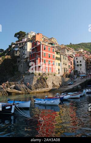 The colourfully painted houses and small boats in the fishing village harbour of Riomaggiore, Cinque Terre National Park, Liguria Italy EU Stock Photo