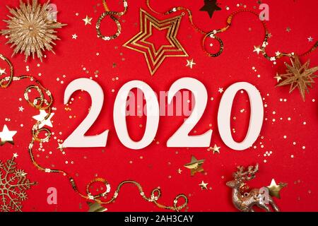 2020 on red background with sparkles. Flat lay style. Stock Photo