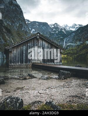 Boathouse at the Obersee in the bavarian alps with mountains in the background and clouds on the sky near berchtesgaden Stock Photo