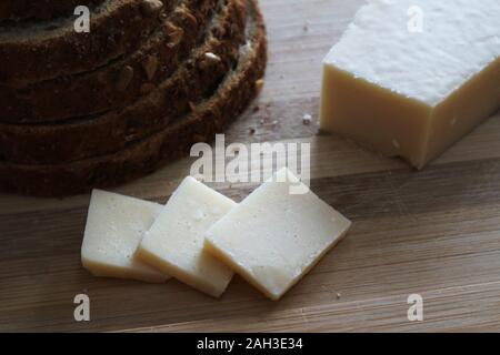 Parmesan cheese on wood cutting board Stock Photo