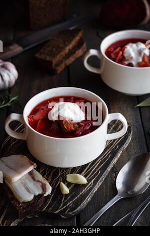 Hot soup. Borsch with red beans and braised beef. Comfortable food. Serving with brown bread and pork fat in a rustic style. Stock Photo
