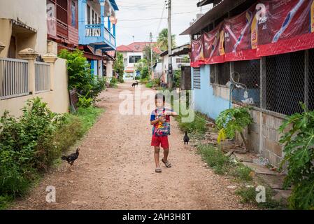 Boy walking on street in Paske, Laos Stock Photo