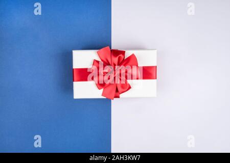Gift box with red bow on beautiful blue gray background Stock Photo