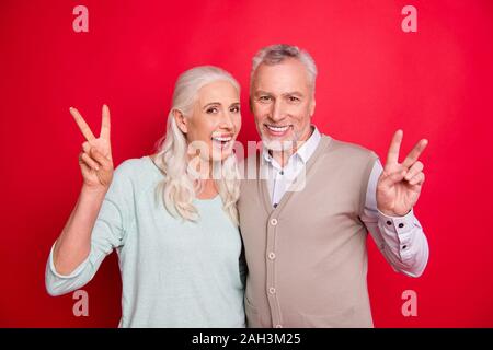 Close up photo amazing beautiful she her he him his aged guy lady hugging holding hands arms show v-sign say hi positive best partners wear sweater Stock Photo