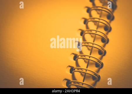 paper in an open spiral notebook, closeup photo, yellow warm tone. Stock Photo