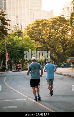Healthy friend jogging on road in park Stock Photo