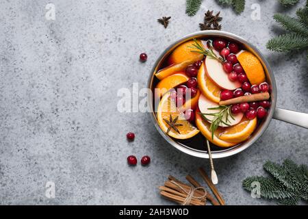 and star anise on black table with fir tree branches. Christmas hot mulled wine with cinnamon, orange and tree on grey stone table. Winter tradition d Stock Photo