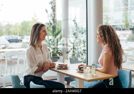 Young students enjoying cake at coffee shop Stock Photo