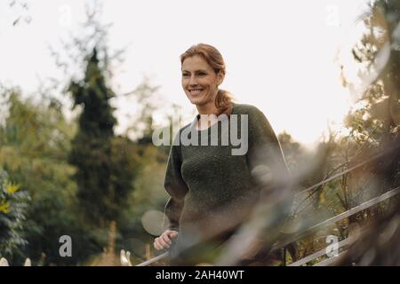 Smiling woman looking into her garden Stock Photo