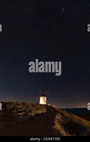 Spain, Province of Toledo, Consuegra, Starry sky over old windmill standing on top of hill at night Stock Photo