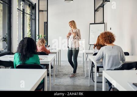 Pregnant woman leading a workshop in office Stock Photo