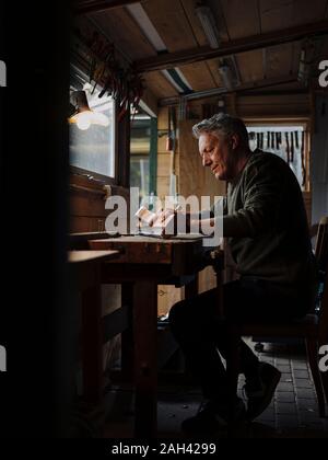 Senior man working on pieceof wood in workshop Stock Photo