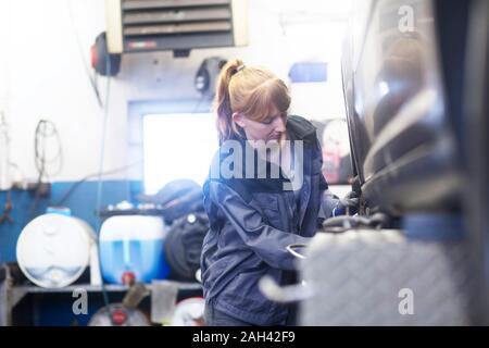 Female car mechanic working in repair garage Stock Photo