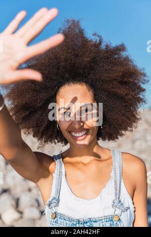 Portrait of young woman, raising arm Stock Photo