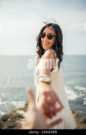 Young woman holding man's hand on viewpoint, Getxo, Spain Stock Photo
