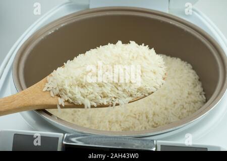 Close up Jasmine rice cooking in electric rice cooker at white background Stock Photo