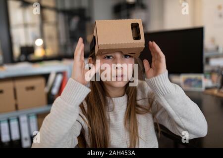 Girl with cardboard VR glasses in office Stock Photo