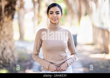 Portait of a smiling young woman in a park Stock Photo