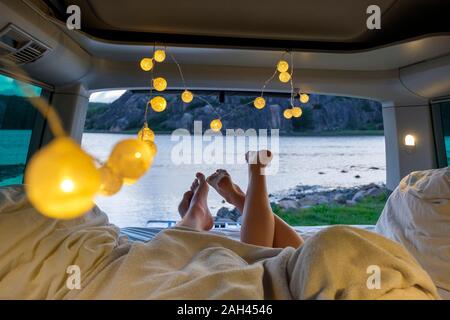 Feet of teenage couple, lying in a camper at the sea Stock Photo
