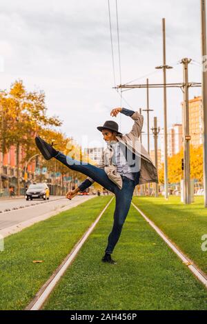 Young man moving and dancing on tram rails Stock Photo