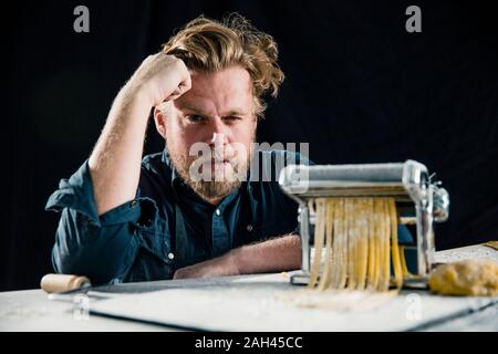 Hobby chef making fresh tagliatelle with pasta machine Stock Photo