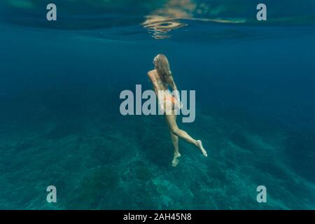 Young woman diving, Nusa Penida island, Bali, Indonesia Stock Photo