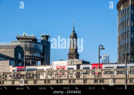 Germany, Hamburg, Elevated train with Saint Michaels Church bell tower in background Stock Photo