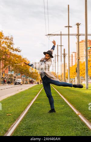 Young man moving and dancing on tram rails Stock Photo