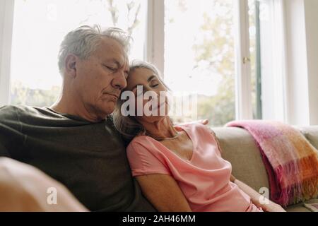 Senior couple napping on couch at home Stock Photo