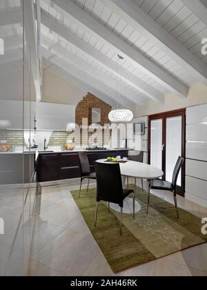 interior shot of a modern kitchen in the attic room with dining table and carpet Stock Photo