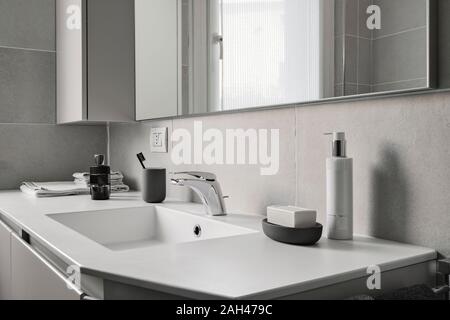 interior shot of a modern bathroom in foreground the integrated washbasin with faucet Stock Photo