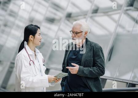 Female doctor talking to senior man Stock Photo