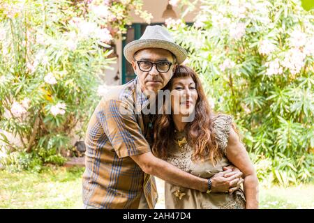 Portrait of mature couple, embracing in garden Stock Photo