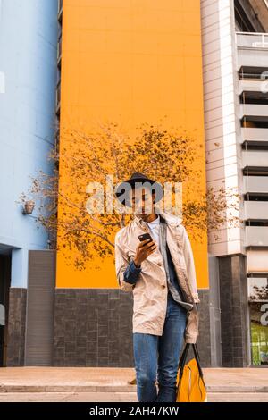 Fashionable young man using smartphone outdoors Stock Photo