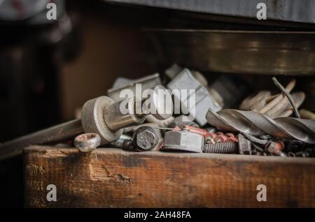 Mess on the workbench. Workbench in the workshop littered with various trash and tools. Eye level shooting. Selective focus. Stock Photo