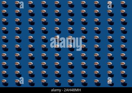 Hot chocolate with marshmallows and a stick of cinnamon on a classic blue background with hard light. Pattern in 2020 color of the year. Stock Photo