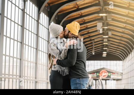 Young couple kissing at a subway station, Berlin, Germany