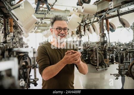 Producer of a fashion label during control in circular knitting mill Stock Photo