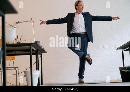 Senior businessman doing a yoga exercise in office Stock Photo