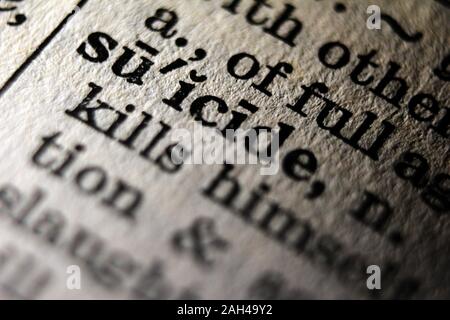 Word "suicide" printed on book page, close-up Stock Photo