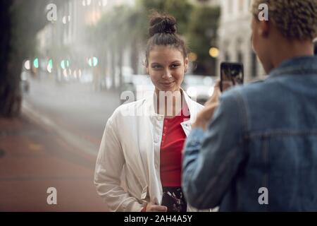 Young woman posing for a smartphone picture in the city Stock Photo