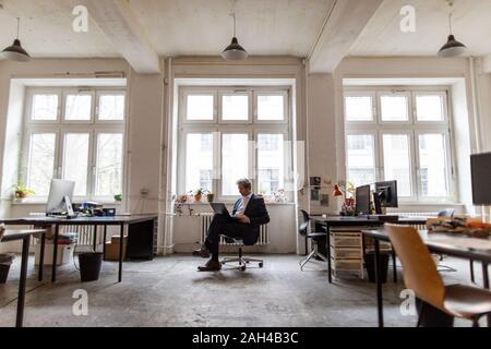 Senior businessman using laptop in office Stock Photo