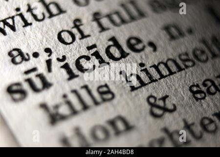 Word "suicide" printed on book page, close-up Stock Photo
