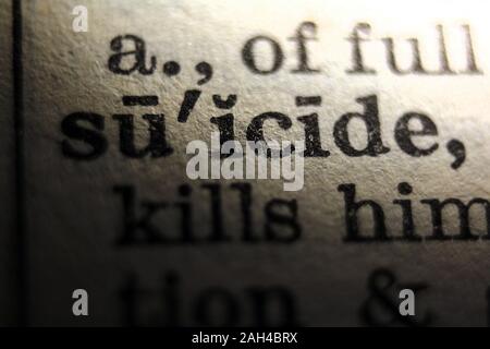 Word "suicide" printed on book page, close-up Stock Photo