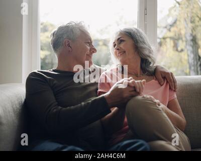 Affectionate senior couple relaxing on couch at home Stock Photo