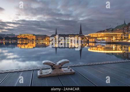 Germany, Hamburg, Jungfernstieg, city seen across river at dawn Stock Photo