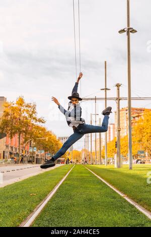 Young man jumping and dancing on tram rails Stock Photo